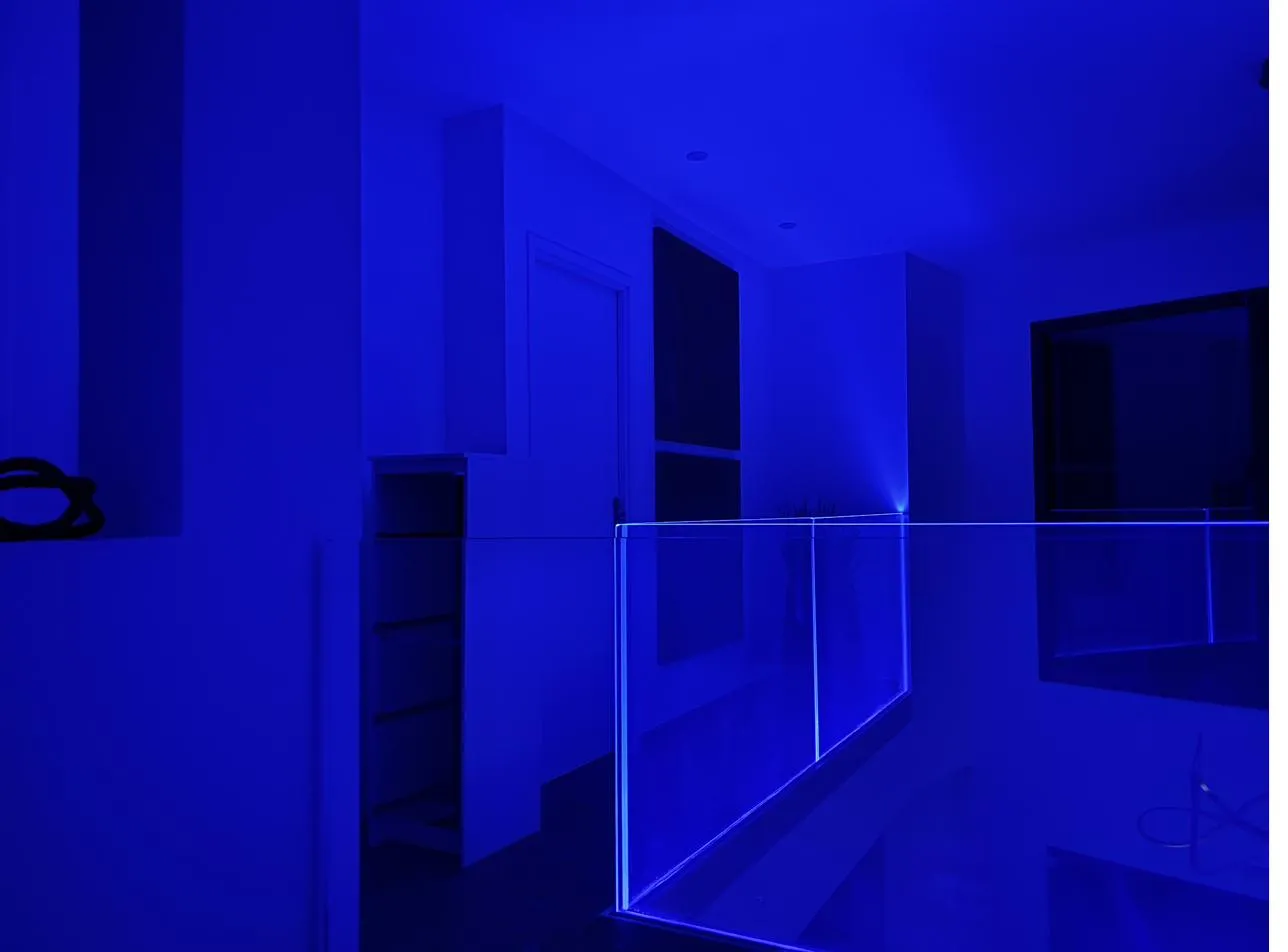 Palier avec garde-corps en verre souligné par un ruban LED RGB bleu